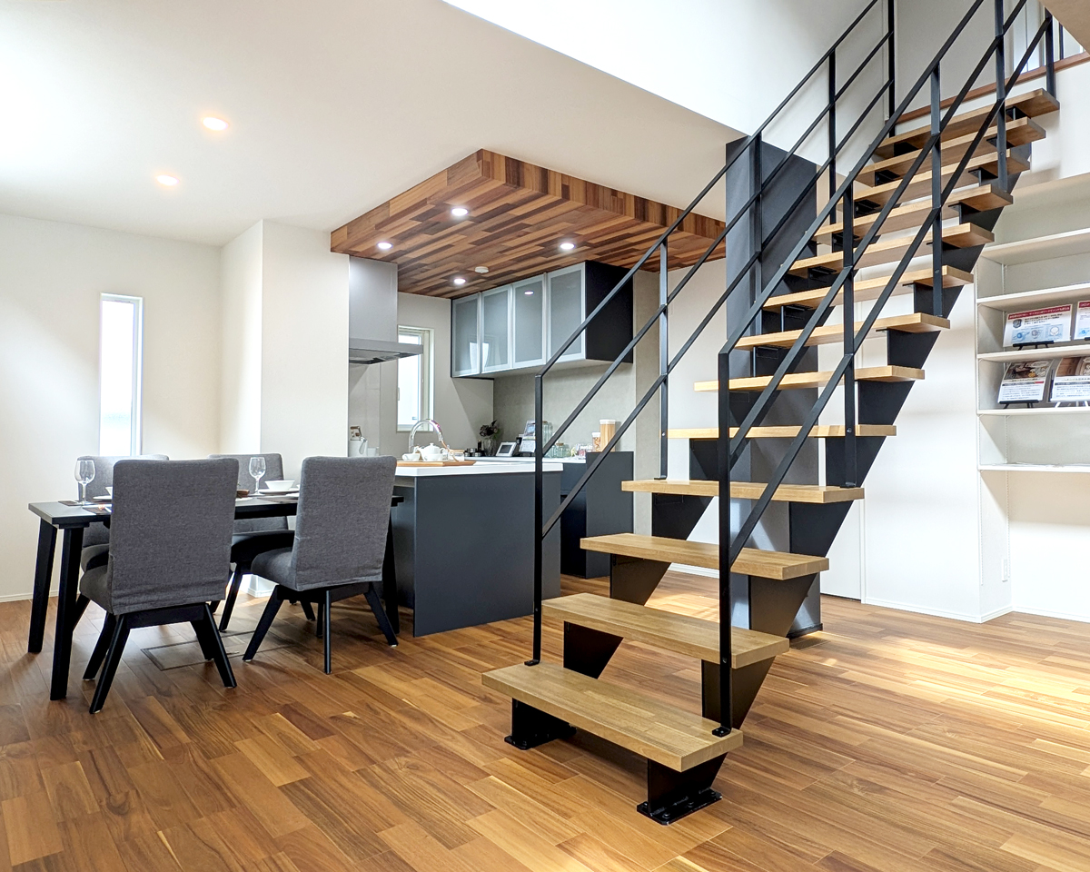 『鉄骨階段』<br />
リビングの中央に配したのこぎり型の鉄骨階段は、住まいのデザインを引き締めるアクセントに。吹き抜けとつながることで光をやさしく取り込み、空間全体に開放感をもたらします。<br />
また、スケルトン構造ならではの抜け感が、リビングに広がりを演出すると同時に、家族の気配を程よく感じられる安心感も。スタイリッシュな佇まいと暮らしやすさを両立した階段の存在感を、モデルハウスで体感してみませんか？